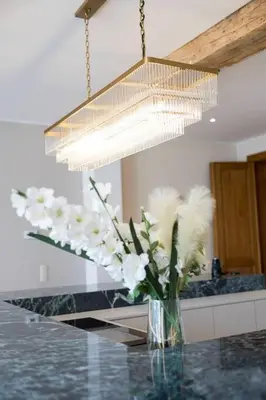 a vase of flowers on a counter under a chandelier at Unique Flat on the GRAND PLACE in Brussels