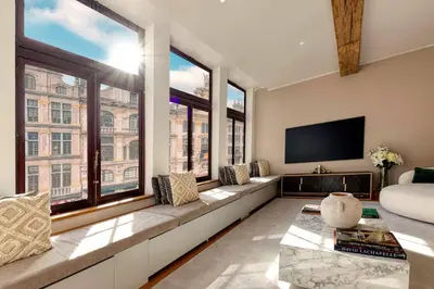 a living room with a couch and a large window at Unique Flat on the GRAND PLACE in Brussels
