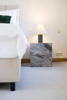 a bedroom with a bed and a table with a lamp at Unique Flat on the GRAND PLACE in Brussels