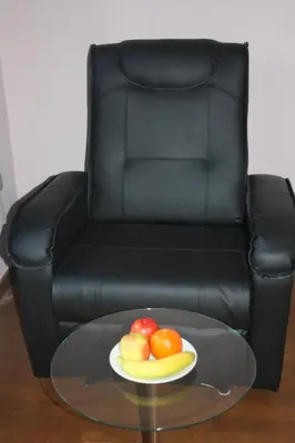 a plate of fruit on a glass table in front of a chair at EU B&B in Brussels