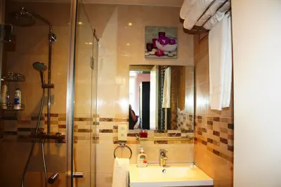 a bathroom with a sink and a shower with a mirror at EU B&B in Brussels