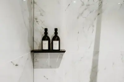 two bottles of wine sitting on a shelf in a bathroom at Gorgeous duplex apartment in old city centre in Antwerp