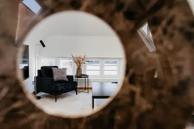 a view of a living room with a chair and a table at Gorgeous duplex apartment in old city centre in Antwerp