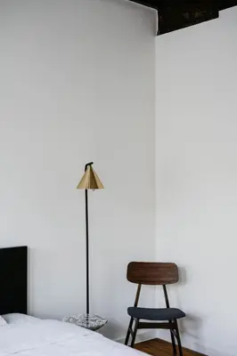 a bedroom with a bed and a chair and a lamp at Gorgeous duplex apartment in old city centre in Antwerp