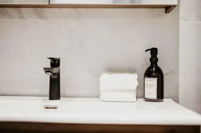 a bottle of wine sitting on a bathroom sink at Gorgeous duplex apartment in old city centre in Antwerp