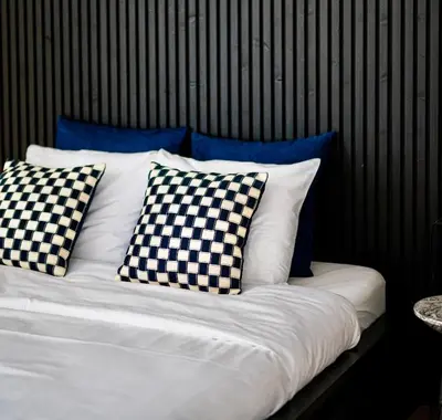 a bed with checkered pillows on it at Modern apartment in the old city center in Antwerp
