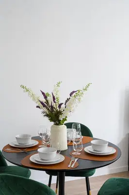 a table with plates and glasses and a vase with flowers at Modern apartment in the old city center in Antwerp