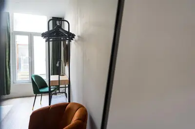 a living room with a chair and a mirror at Modern apartment in the old city center in Antwerp