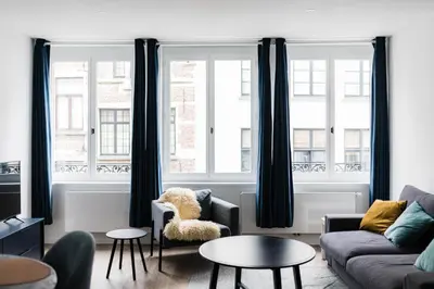 a living room with a couch and two windows at Gorgeous getaway in the old city centre of Antwerp in Antwerp