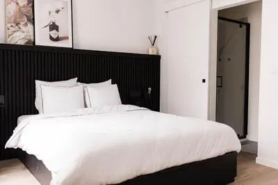 a bedroom with a large white bed with a black headboard at Gorgeous getaway in the old city centre of Antwerp in Antwerp