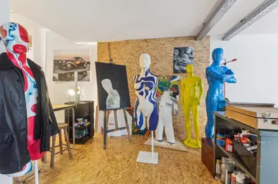 a room with a group of mannequins and paintings at Cosy art studio near station with bikes and garden in Ghent