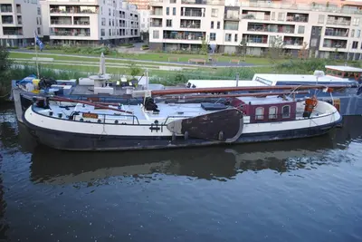 a boat is docked in the water in a city at Boat & Breakfast Bellevue in Ghent