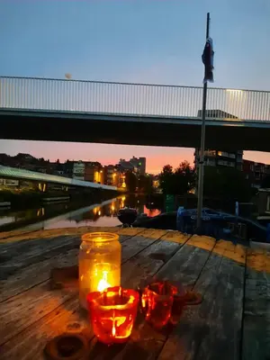 a couple of candles on a wooden table with a bridge at Boat & Breakfast Bellevue in Ghent