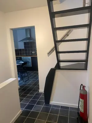 a stairway in a room with a kitchen and a table at Bubbles and More Guesthouse in Begijnendijk