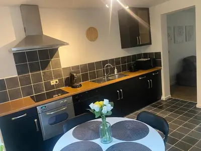 a kitchen with a table with a vase of flowers on it at Bubbles and More Guesthouse in Begijnendijk