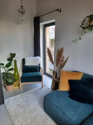 a living room with a couch and a chair and a window at Ateljee Sohie in Hoeilaart