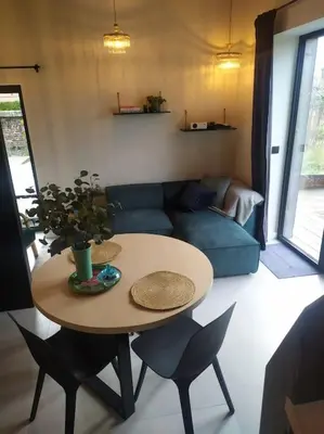 a living room with a table and a blue couch at Ateljee Sohie in Hoeilaart