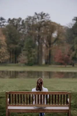 a woman sitting on a bench in a park at B&B Kasteel Den Tip in Arendonk