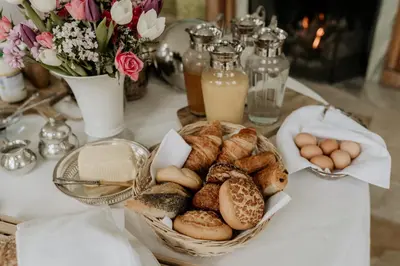 a table topped with a basket of bread and eggs at B&B Kasteel Den Tip in Arendonk