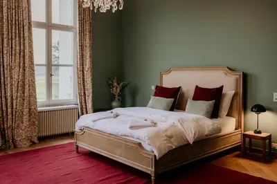 a bedroom with a large bed with red pillows at B&B Kasteel Den Tip in Arendonk