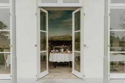 a white house with a table in the doorway at B&B Kasteel Den Tip in Arendonk