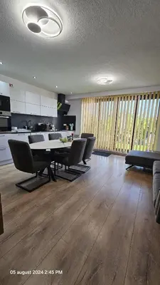 a living room with a table and chairs and a kitchen at Casa Luca in Grimbergen