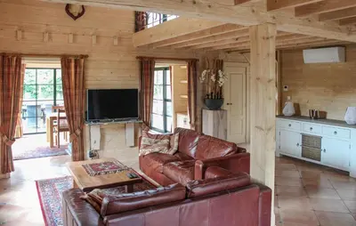 a living room with a leather couch and a tv at 2 Bedroom Cozy Home In Arendonk in Arendonk