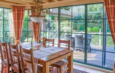 a dining room with a table and a large window at 2 Bedroom Cozy Home In Arendonk in Arendonk
