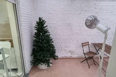 a christmas tree in a room with a table and a lamp at Worker's Lodge - 2 Bedrooms & Court yard - Antwerp Smooth Stays in Antwerp