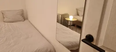 a small room with a bed and a mirror at Worker's Lodge - 2 Bedrooms & Court yard - Antwerp Smooth Stays in Antwerp
