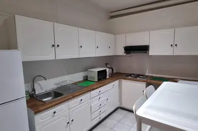 a kitchen with white cabinets and a sink at Worker's Lodge - 2 Bedrooms & Court yard - Antwerp Smooth Stays in Antwerp