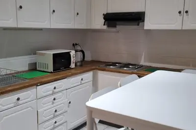 a kitchen with white cabinets and a microwave on a counter at Worker's Lodge - 2 Bedrooms & Court yard - Antwerp Smooth Stays in Antwerp