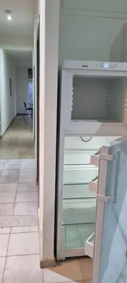 an empty refrigerator with its door open in a hallway at Worker's Lodge - 2 Bedrooms & Court yard - Antwerp Smooth Stays in Antwerp