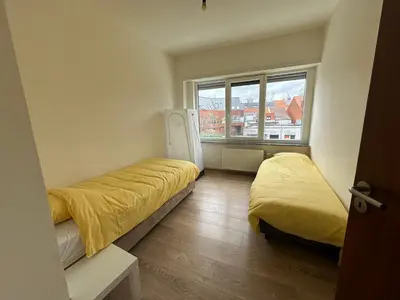 a small room with two beds and a window at Spacious Apartment next to Port of Antwerp in Antwerp