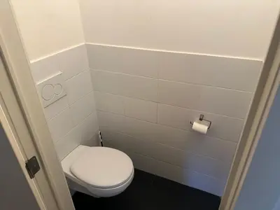 a bathroom with a toilet and a toilet paper roll at Spacious Apartment next to Port of Antwerp in Antwerp