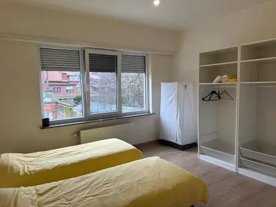 a bedroom with two beds and a large window at Spacious Apartment next to Port of Antwerp in Antwerp