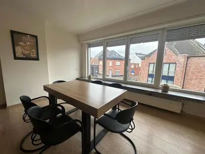 an empty room with a wooden table and chairs and windows at Spacious Apartment next to Port of Antwerp in Antwerp