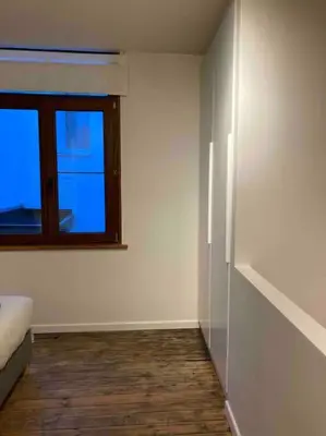 an empty room with a window and a bed at Idyllische, historische woning op het hippe zuid in Antwerp