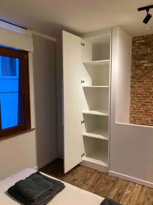a room with a closet with shelves and a window at Idyllische, historische woning op het hippe zuid in Antwerp