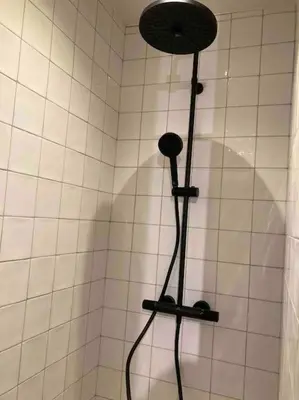 a shower with a shower head in a bathroom at Idyllische, historische woning op het hippe zuid in Antwerp