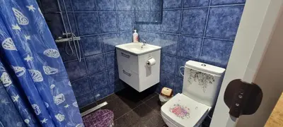 a bathroom with a toilet and a blue tiled wall at Studio Alex in Ghent