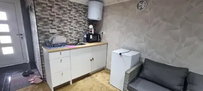 a kitchen with a counter and a refrigerator and a couch at Studio Alex in Ghent