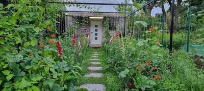 a garden with a pathway leading to a white door at Studio Alex in Ghent