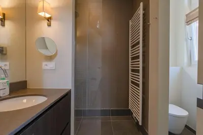 a bathroom with a sink and a glass shower at 1000m2 villa with indoor pool in Brussels