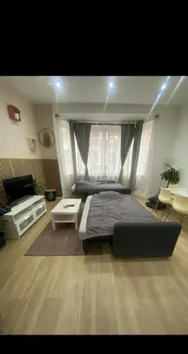 a bedroom with a bed and a couch and a table at Modern Apartment in Molenbeek-Saint-Jean / 77 m² / Parking in Brussels
