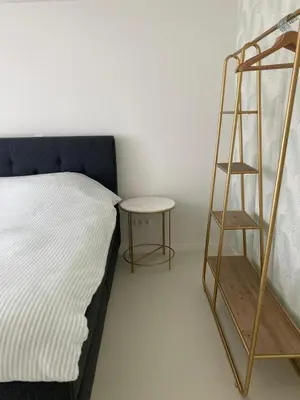 a bedroom with a bed and a ladder next to a table at Charmante stadswoning aan Groen Kwartier in Antwerp