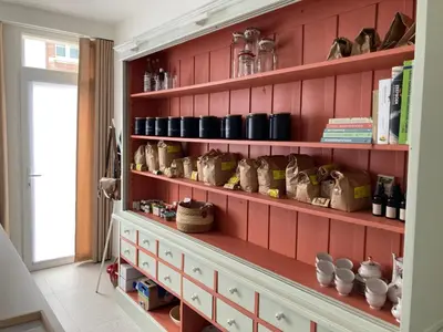 a room with a red wall with shelves with cups at Charmante stadswoning aan Groen Kwartier in Antwerp