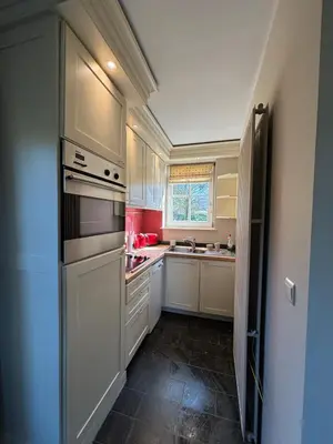 a kitchen with white cabinets and a stove top oven at Duplex Rosières - 12’ de Bruxelles in Rixensart