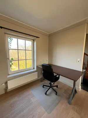 an empty office with a desk and a window at Duplex Rosières - 12’ de Bruxelles in Rixensart