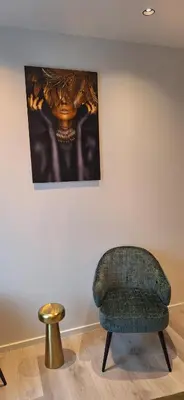 a green chair and a gold stool in a room at Den Ommegang in Halle